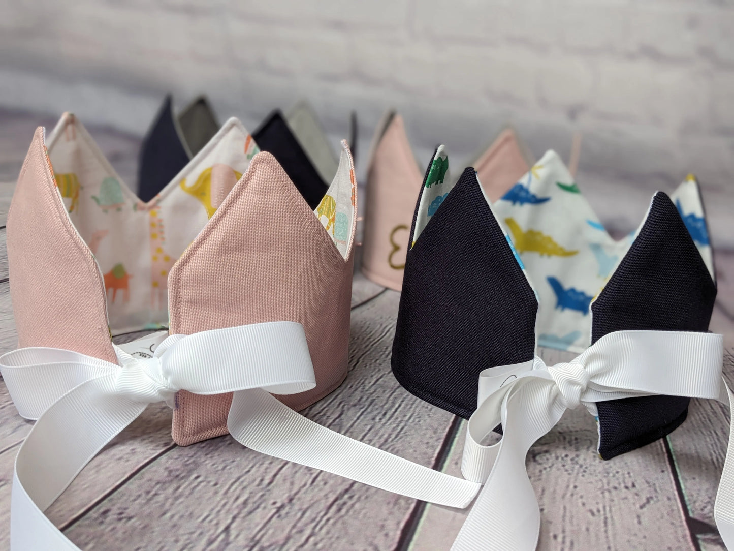 closeup-back-of-pink-and-blue-crowns-showing-ribbon-ties-dino-and-safari-pattern