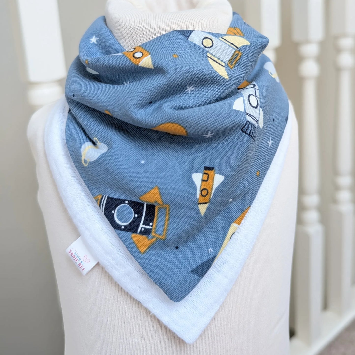 Baby bib with space-themed design on a white surface