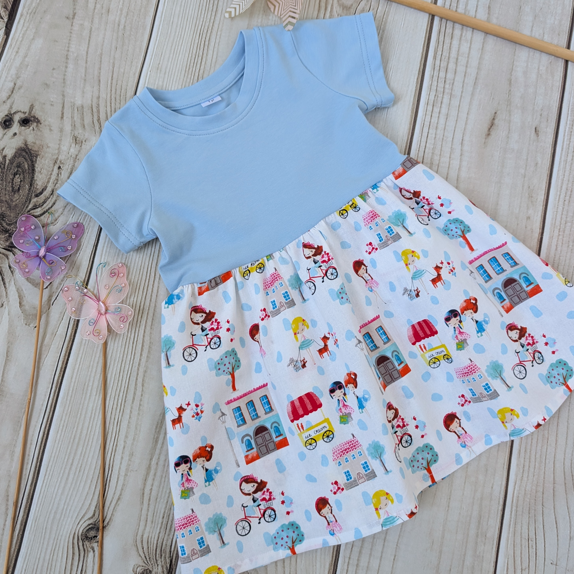 Close-up-Flatlay-Blue-jersey-Bodice-Gathered-cotton-Skirt-Girls-Bikes-Ice-Cream-Trees-props-butterflies-and-windmill