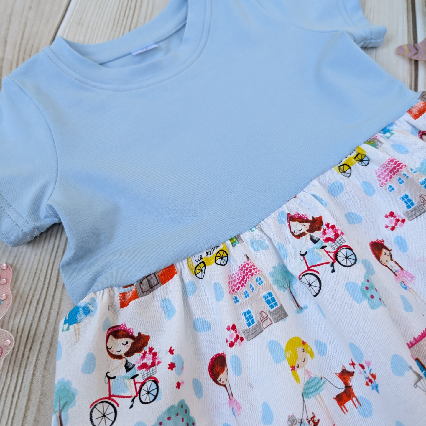 Close-up-Flatlay-Blue-jersey-Bodice-Gathered-cotton-Skirt-Girls-Bikes-Ice-Cream-Trees-props-butterflies-and-windmill