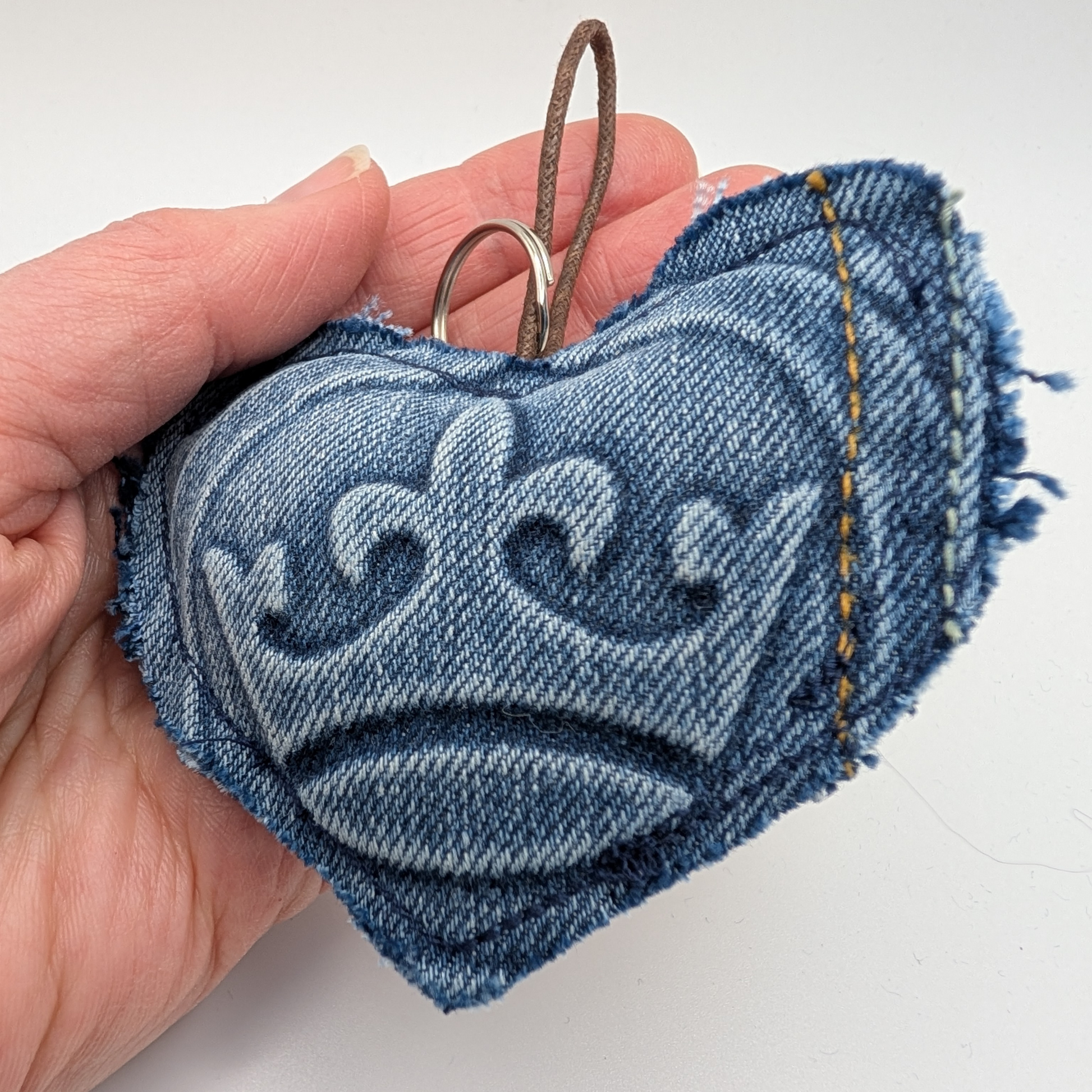 hand-holding-heart-shaped-keyring-with-crown-embossed-detail