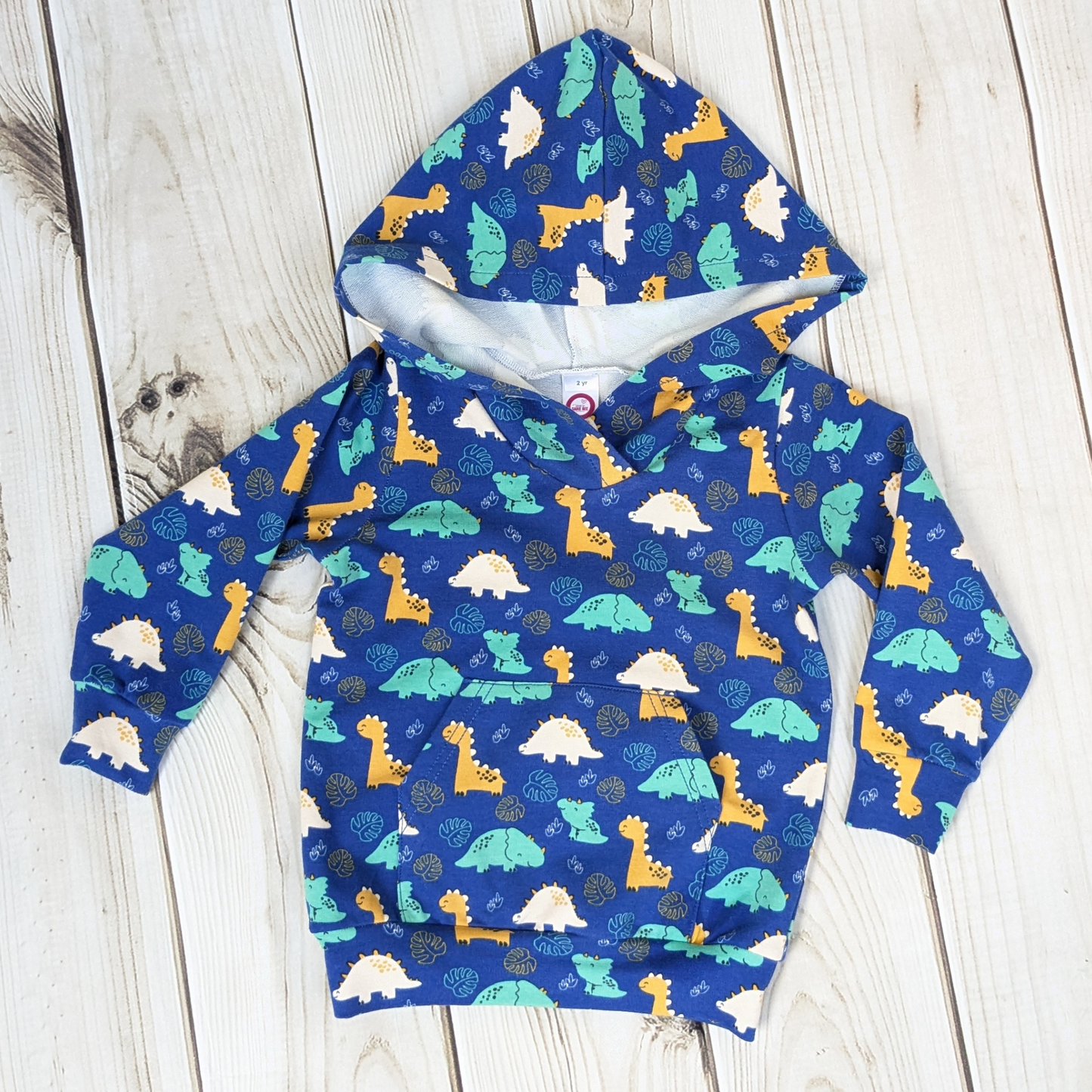 flatlay-dino-pattern-hoodie-blue-smiling-dinosaurs