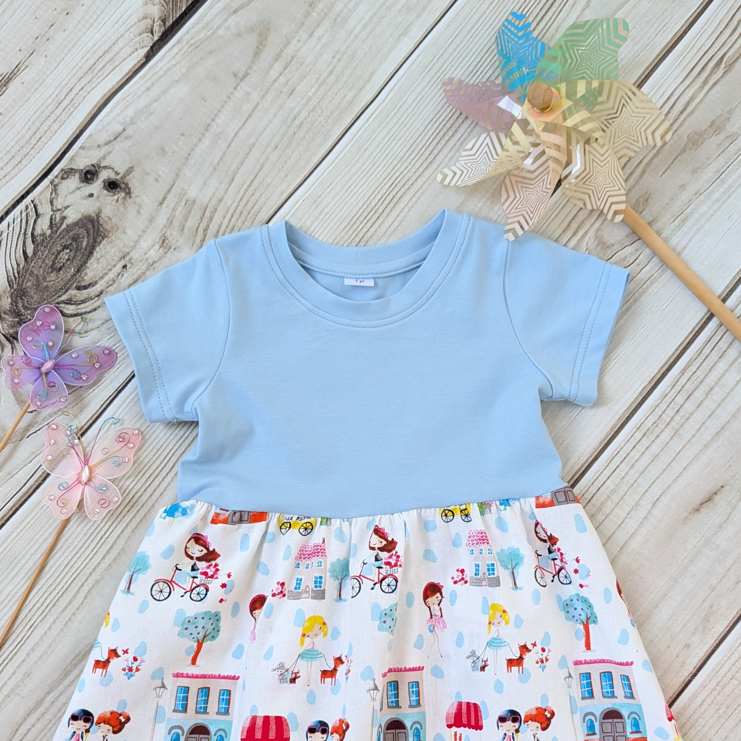 Close-up-Flatlay-Blue-jersey-Bodice-Gathered-cotton-Skirt-Girls-Bikes-Ice-Cream-Trees-props-butterflies-and-windmill