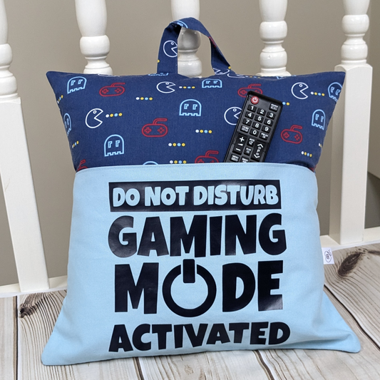 Blue gaming design pocket cushion with remote control inthe pocket or display purposes. Slogan says Do Not Disturb Gaming Mode Activated.