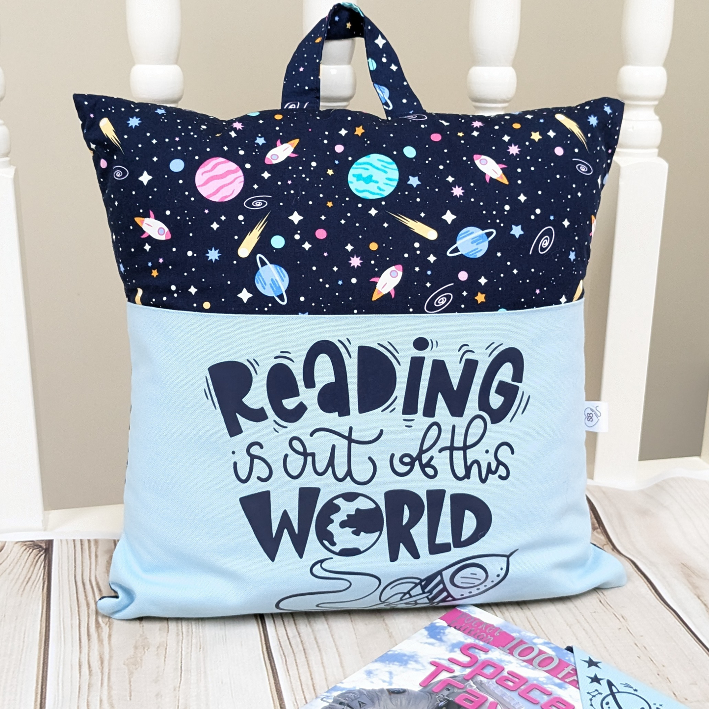 Space themed reading pocket cushion with slogan Reading isout of this World. With Bookmark & Book. Pocket with slogan.