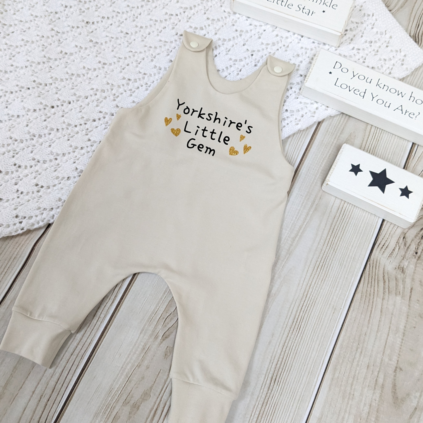 neutral-beige-long-leg-romper-with-phrase-yorkshire's-little-gem-gold-hearts-front-beige-shoulder-snaps-photo-props