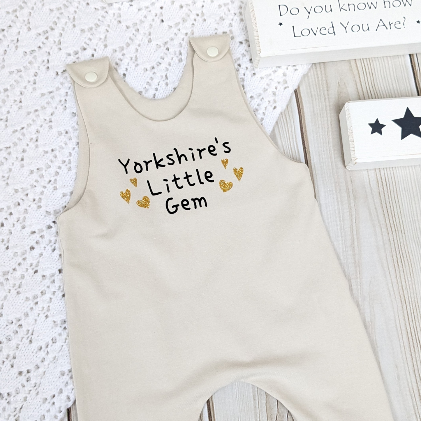 neutral-beige-long-leg-romper-with-phrase-yorkshire's-little-gem-gold-hearts-front-beige-shoulder-snaps-photo-props