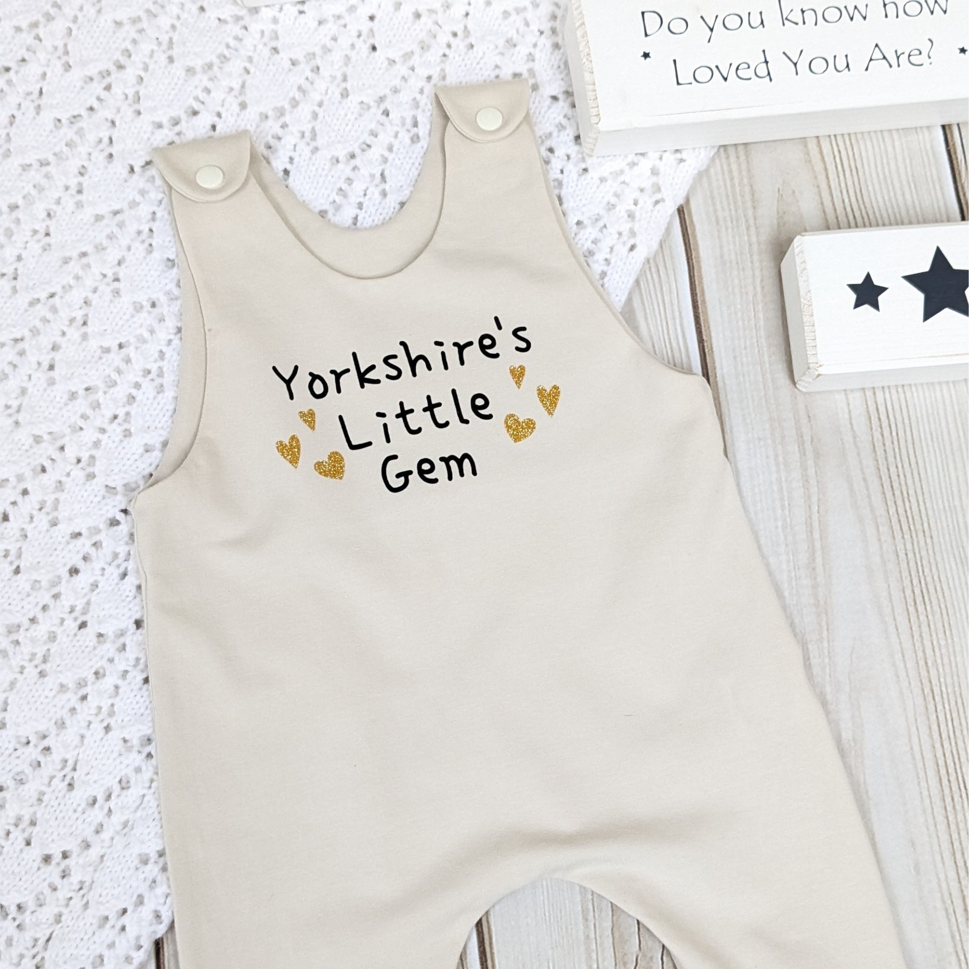 neutral-beige-long-leg-romper-with-phrase-yorkshire's-little-gem-gold-hearts-front-beige-shoulder-snaps-photo-props