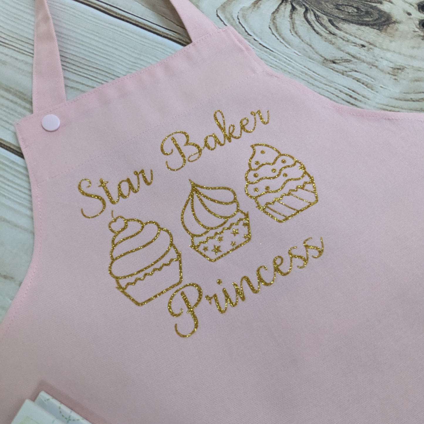 Pink-Handmade-Kids-apron-star-baker-row-of-cupcakes-gold-sparkly-words-Princess-used-as-an-example